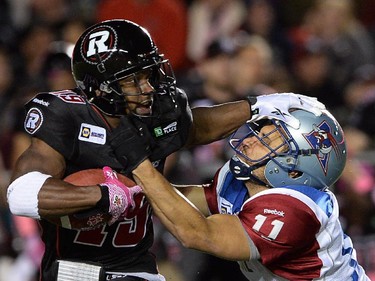 Ottawa Redblacks' Roy Finch gets tackled by Montreal Alouettes' Chip Cox during CFL action in Ottawa on Friday, Oct 24, 2014.