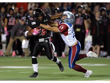 Ottawa Redblacks' Roy Finch gets tackled by Montreal Alouettes' Chip Cox during CFL action in Ottawa on Friday Oct 24, 2014.