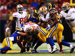 Carlos Hyde of the San Francisco 49ers is tackled by  James Laurinaitis of the St. Louis Rams during NFL game on Oct. 13, 2014 in St Louis.