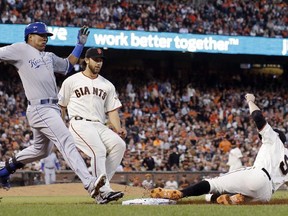 San Francisco Giants' Brandon Belt slides into first to force out Kansas City Royals' Salvador Perez during the fourth inning of Game 5 of baseball's World Series Sunday, Oct. 26, 2014, in San Francisco.