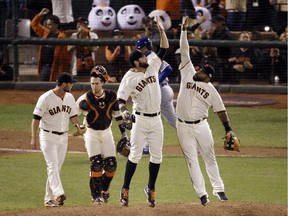 San Francisco Giants' Pablo Sandoval, right, leaps for a high five with Brandon Belt as catcher Buster Posey and pitcher Hunter Strickland, far left, walk off the field after Game 4 of baseball's World Series against the Kansas City Royals on Saturday, Oct. 25, 2014, in San Francisco. The Giants won the game 11-4 to tie the series 2-2.