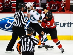 The Devils' Jordin Tootoo (right) fights with the San Jose Sharks' Andrew Desjardins during game at New Jersey's Prudential Center on Oct, 18, 2014.