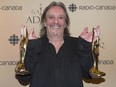 Serge Fiori holds up his Felix award for best adult contempory album at the gala Adisq awards ceremony in Montreal, Sunday, October 26, 2014.