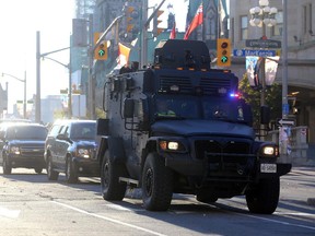 OTTAWA, CANADA - OCTOBER 22: A tactical vehicle leaves the security perimeter on Wellington Street, just a couple blocks away from Parliament Hill, on October 22, 2014 in Ottawa, Canada. At least one gunman shot and killed a Canadian soldier standing guard at the National War Memorial before entering the House of Commons inside the main Parliament building and opening fire. The gunman, identified as Michael Zehaf-Bibeau, was shot and killed by law enforcement while still inside the Parliament building.
