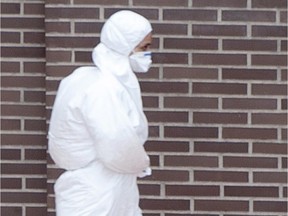 A members of a sanitation team works in protective suit outside the residence of Teresa, a Spanish nurse, and her husband Javier Limon on October 8, 2014 in Alcorcon.