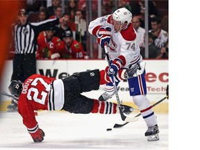 Alexei Emelin of the Montreal Canadiens hits Johnny Oduya of the Chicago Blackhawks during a preason game at the United Center on Oct. 1, 2014 in Chicago, Illinois.