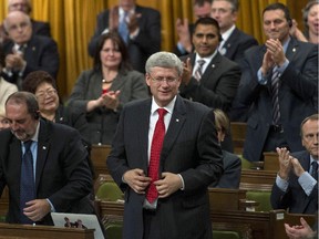 Canadian Prime Minister Stephen Harper rises in the House of Commons on Parliament Hill to vote for an air combat mission against ISIS on Tuesday, Oct. 7, 2014. While Harper insists we won't be going to the polls this year before the fixed election date of Oct. 19, could political circumstances - and opportunities - see that date pushed forward ?