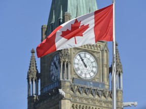 The Canadian flag flies in front of the Peace Tower on Parliament Hill in Ottawa on Friday, Oct. 3, 2014.