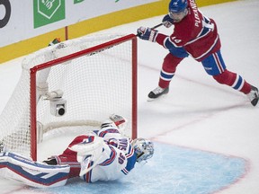 Montreal Canadiens' Tomas Plekanec, right, scores against the New York Rangers goaltender Henrik Lundqvist during first period NHL hockey action in Montreal, Saturday, October 25, 2014.