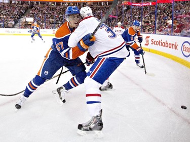 Montreal Canadiens' Travis Moen and Edmonton Oilers' David Perron battle in the corner during first=period action in Edmonton on Monday, Oct. 27, 2014.