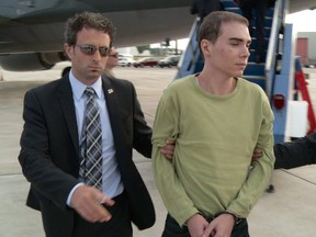 Luka Magnotta is taken by police from a Canadian military plane to a waiting van on Monday, June 18, 2012, in Mirabel.