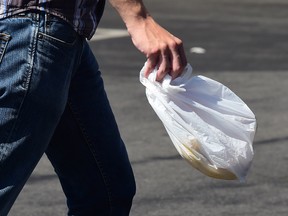 A man carries a plastic bag while leaving a supermarket in Los Angeles, California on September 30, 2014, where the state's Governor has signed the country's first statewide ban on single-use plastic bags from convenience and grocery stores. The ban, scheduled to take effect in July 2015, has led to a national coalition of plastic bag manufacturers immediately saying it will seek a voter referendum to repeal the law. AFP PHOTO / Frederic J. BROWNFREDERIC J. BROWN/AFP/Getty Images