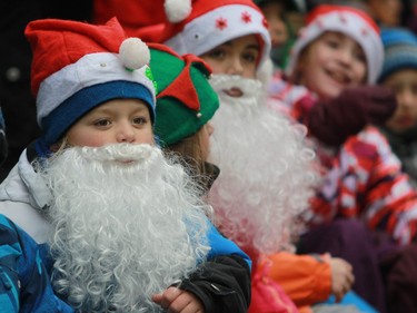 Youngsters watch the Santa Claus parade on Ste-Catherine St. in Montreal on Saturday, Nov. 22, 2014.