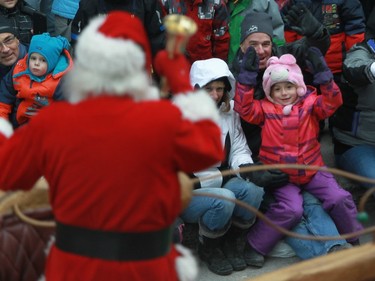 Happy faces all around as Santa Claus passes by on Ste-Catherine St. in Montreal on Saturday, Nov. 22, 2014.