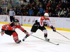 William Carrier #22 of the Drummondville Voltigeurs skates with the puck while being defended by Cody Donaghey #18 of the Quebec Remparts during the QMJHL game at the Centre Marcel Dionne on February 23, 2014 in Drummondville, Quebe.