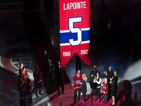 Former Montreal Canadiens defenceman Guy Lapointe and his wife, Louise, look on as his number is raised during a retirement ceremony prior to the Canadiens-Minnesota Wild game in Montreal on Saturday.