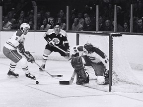 Boston Bruins forward Johnny Bucyk watches Canadiens goalie Ken Dryden and helmeted defenceman J.C. Tremblay repel a Boston attack during a 1970s game at the Montreal Forum.