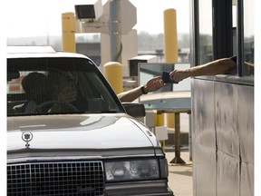 A Canadian border guard hands back a document to a person entering Canada at the St. Bernard de Lacolle border crossing Wednesday, October 3, 2007.