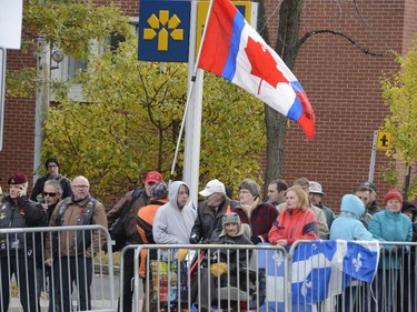 A man carries a homemade Quebec-Canada flag at the funeral for warrant officer Patrice Vincent in Longueuil, Que., Saturday, Nov. 1, 2014. Vincent died after being hit by a car driven by an attacker with known jihadist sympathies on Oct. 20 in the parking lot of a shopping mall in Saint-Jean-sur-Richelieu, southeast of Montreal.
