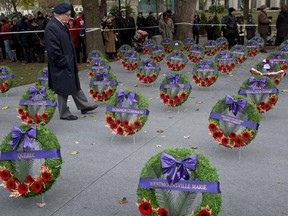 A veteran walks through rows of wreaths prior to Remembrance Day ceremonies Monday, November 11, 2013 in Montreal.