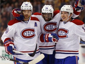 Montreal Canadiens defenceman Andrei Markov (79) celebrates his goal with teammates P.K. Subban (76) and Brendan Gallagher during the first period of an NHL hockey game against the Boston Bruins in Boston, Saturday, Nov. 22, 2014.