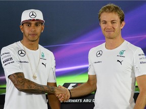 Lewis Hamilton, left, and Nico Rosberg shake hands before a press conference at the Yas Marina circuit on Nov. 20, 2014 ahead of the Abu Dhabi Formula One Grand Prix.