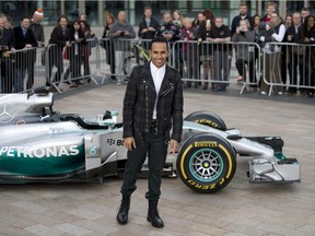 Lewis Hamilton poses with a Mercedes F1 car in Salford, England, on Nov. 25, 2014. The 29-year-old became the first Brit to win more than one F1 championship since 1968, and the fourth British driver ever to do so, when he won the Abu Dhabi Grand Prix to secure the title he first won  in 2008.
