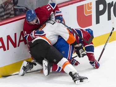 Philadelphia Flyers' Nicklas Grossmann gets tangled up with Montreal Canadiens' Brendan Gallagher, top, and Tomas Plekanec during first period NHL hockey action Saturday, November 15, 2014 in Montreal.