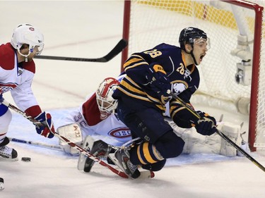 Buffalo Sabres' Zemgus Girgensons is hooked by Montreal Canadiens' David Desharnais during the first period Wednesday, Nov. 5, 2014, in Buffalo, N.Y.