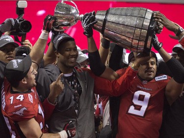 Calgary Stampeders running back Jon Cornish (9) and teammates try hold the top of the Grey Cup in place after it came apart while celebrating their victory over the Hamilton Tiger-Cats in the 102nd Grey Cup in Vancouver, B.C. Sunday, Nov. 30, 2014.