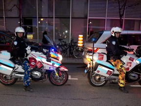 Motorcycle cops wearing casual trousers stand parked  on a street November 04, 2014 in Montreal  to protest the Quebec provincial government proposal to reduce costs of municipal pensions by having workers contribute more toward their retirement. The city contends union pressure tactics have cost it $13 million in  potential revenue from traffic tickets.