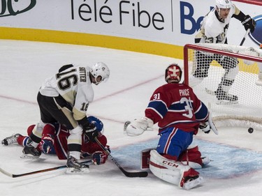 Pittsburgh Penguins' Steve Downie scores on Carey Price as Canadiens' Tom Gilbert and Penguins' Brandon Sutter look on during first period NHL hockey action Tuesday, November 18, 2014 in Montreal.