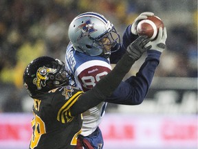 Alouettes wide receiver Duron Carter makes a catch while being defended against by Hamilton Tiger-Cats defensive back Ed Gainey during the first half of the CFL football game in Hamilton on Saturday, November 8, 2014.