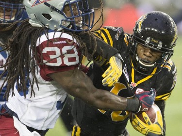 Hamilton Tiger-Cats Brandon Banks (16) fights off Montreal Alouettes defensive back Dominique Ellis (38) during the first half of the CFL football game in Hamilton, Ont., on Saturday, November 8, 2014.
