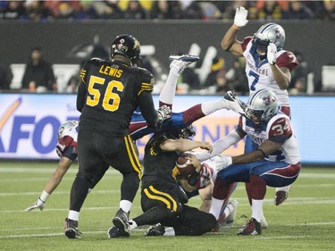 Hamilton Tiger-Cats quarterback Zach Collaros (4) is swarmed after he regained possession of the football following a high snap during the first half of the CFL football game in Hamilton, Ont., on Saturday, November 8, 2014.
