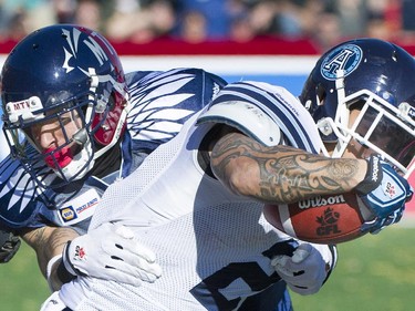 Toronto Argonauts' Chad Owens, right, is tackled by Montreal Alouettes' Mitchell White during first half CFL football action in Montreal, Sunday, November 2, 2014.