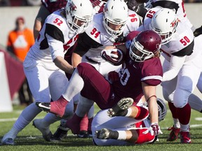 McMaster Marauders running back Chris Pezzetta, centre, is taken down by Guelph Gryphons, from left, Cameron Walker, Blake McNeely, and Andrew Graham during first half Yates Cup football action in Hamilton, Ont., Saturday, November 15, 2014.