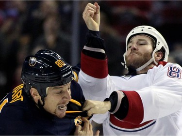Buffalo Sabres right winger Chris Stewart (80) dodges a punch from Montreal Canadiens left winger Brandon Prust (8) during a fight in the first period of an NHL hockey game Friday, Nov. 28, 2014, in Buffalo, N.Y.