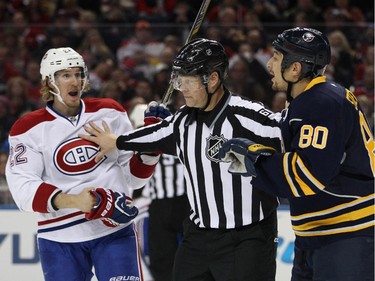 Montreal Canadiens right winger Dale Weise (22) and Buffalo Sabres right winger Chris Stewart (80) get separated by NHL linesman Scott Driscoll (68) as they have words during the second period of an NHL hockey game Friday, Nov. 28, 2014, in Buffalo, N.Y.