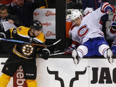 Boston Bruins' Daniel Paille, left, checks Montreal Canadiens' Alexei Emelin over the boards during the second period of an NHL hockey game in Boston, Saturday, Nov. 22, 2014.