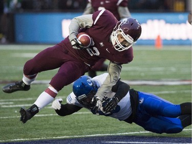 McMaster Marauders' Daniel Petermann, left, is tackled by Montreal Carabins' Maiko Zepeda during second half CIS Vanier Cup football action in Montreal Saturday, November 29, 2014.