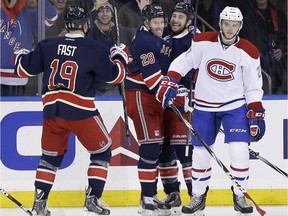 New York Rangers' Dominic Moore, second from left, celebrates his goal with teammates Jesper Fast (19) and Tanner Glass, second from right, while Montreal Canadiens' Alex Galchenyuk skates away during the first period of the NHL hockey game, Sunday, Nov. 23, 2014, in New York.