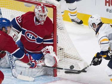 Buffalo Sabres' Brian Gionta, right, moves in on Montreal Canadiens goaltender Dustin Tokarski as Canadiens' Alexei Emelin defends during first period NHL hockey action in Montreal, Saturday, November 29, 2014.