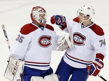 Montreal Canadiens goalie Dustin Tokarski (35) celebrates beating the Detroit Red Wings 4-1 with Montreal Canadiens defenseman Alexei Emelin (74) in the third period of an NHL hockey game in Detroit Sunday, Nov. 16, 2014.