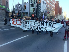 Protesters march in downtown Montreal on Ste. Catherine St. in a demonstration against pipeline projects in Quebec, Saturday Nov. 15, 2014.
