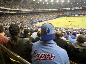 A fan wearing an Expos jersey watches the Toronto Blue Jays in a pre-season game against the New York Mets at Olympic Stadium on March 28, 2014.