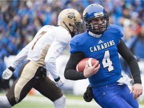 Montreal Carabins quarterback Gabriel Cousineau breaks away from Manitoba Bisons' Jayden McKoy to score a touchdown during first half CIS university football semifinal action in Montreal, Saturday, November 22, 2014.