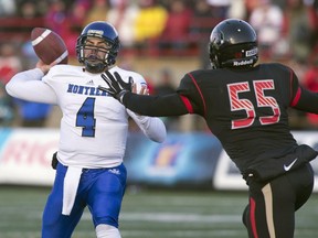 Montreal Carabins quarterback Gabriel Cousineau throws a pass as Laval Rouge et Or Mathieu Masseau fails to stop him during first half Dunsmore Cup action, on Saturday, November 15, 2014 in Quebec City.