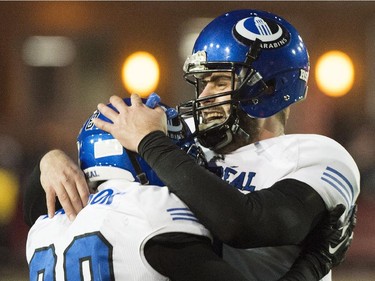 Montreal Carabins' quarter back Gabriel Cousineau, right, celebrates with teammate Mikhail Davidson after beating the McMaster Marauders in the CIS Vanier Cup football final in Montreal Saturday, November 29, 2014.