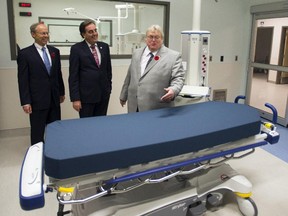 Quebec Health Minister Gaétan Barrette,right, MUHC chief executive Normand Rinfret, center, and SNC-Lavalin chief executive Robert Card, left, tour the new McGill University Health Centre (MUHC) super-hospital Friday, November 7, 2014 in Montreal.